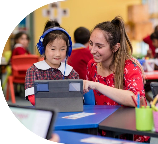 Student with headphones on with teacher